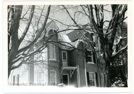 Undated black-and-white winter photograph of the Joseph Lundy House with mature trees in front