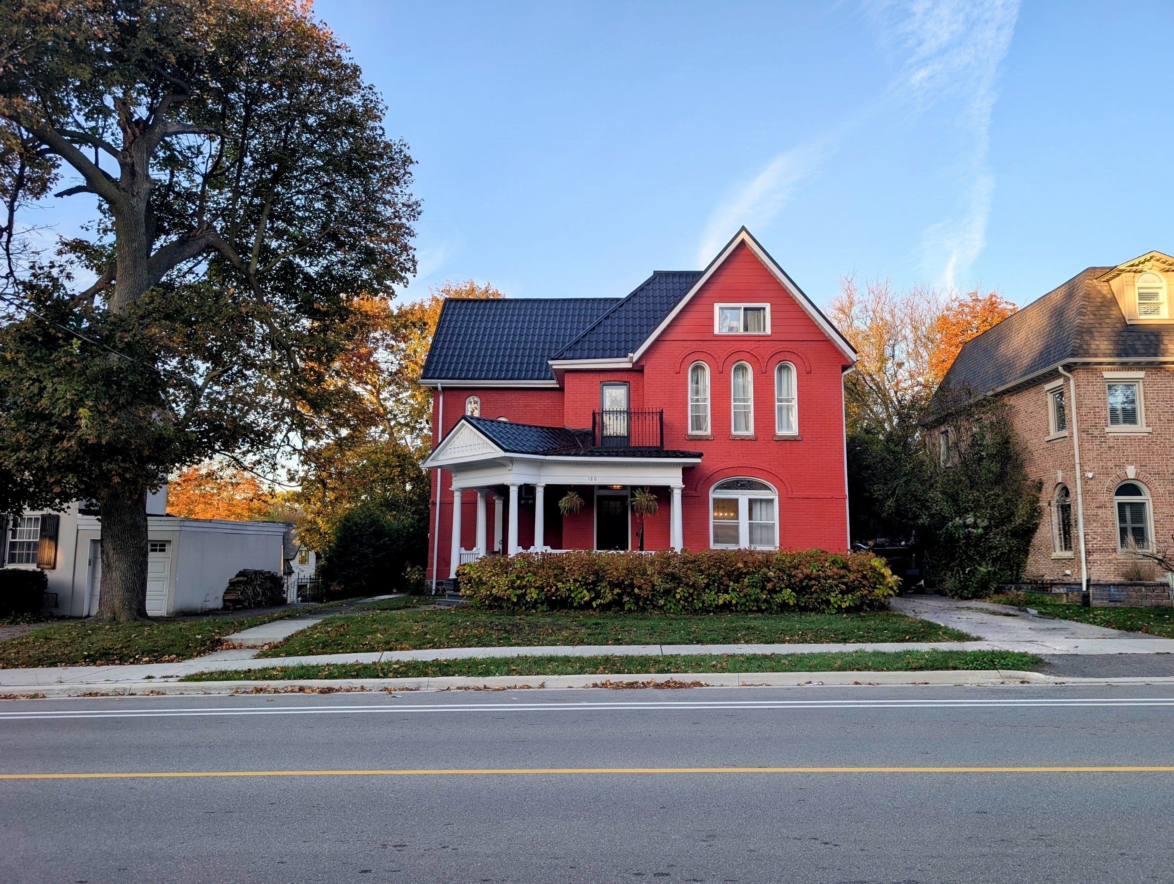Westbourne House at 180 Lorne Avenue, with its red brick Queen Anne facade framed by autumn trees