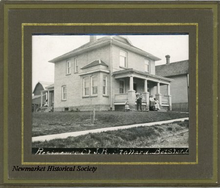 Archival photograph captioned Residence of J. R. Stallard, Botsford, showing the house, verandah, people on the steps and outbuildings beyond